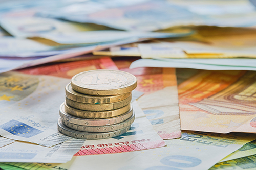 Euro money, euro currency, coins stacked on top of each other in different positions against the background of euro banknotes. Business finance concept, business news splash screen, banner mockup