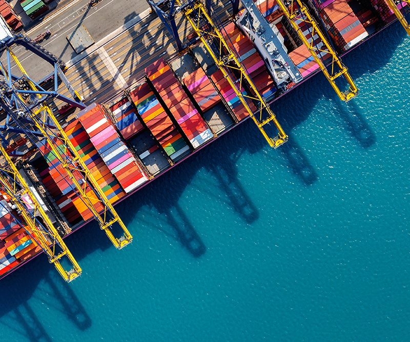 Aerial view of cargo ship and cargo container in harbor.